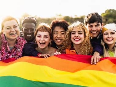 A group of friends outside holding pride flag
