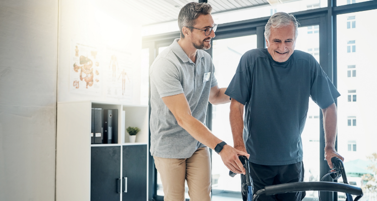 Physiotherapist supporting patient with Parkinson's disease with walking exercise