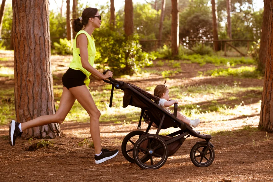 Woman runs wit the stroller in the park